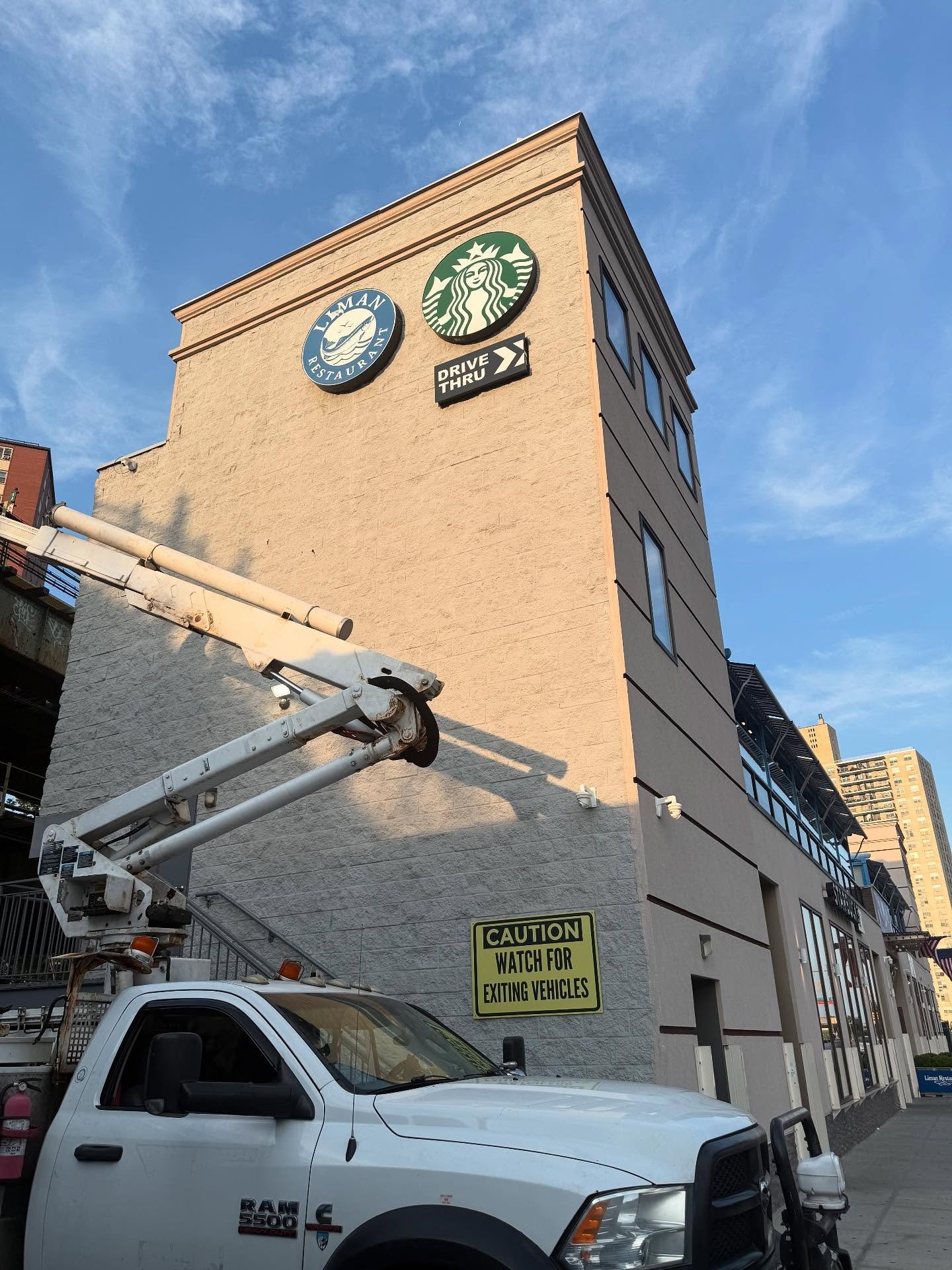 Bucket truck crew installing a building sign